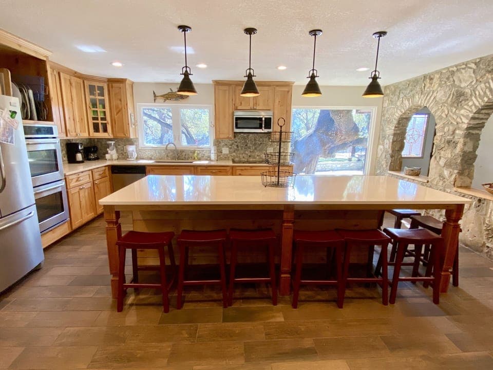 Kitchen - Professional kitchen, with polished stone counters, double oven, rock wall, stainless appliances. Bright & light. Huge 8 person bar counter.