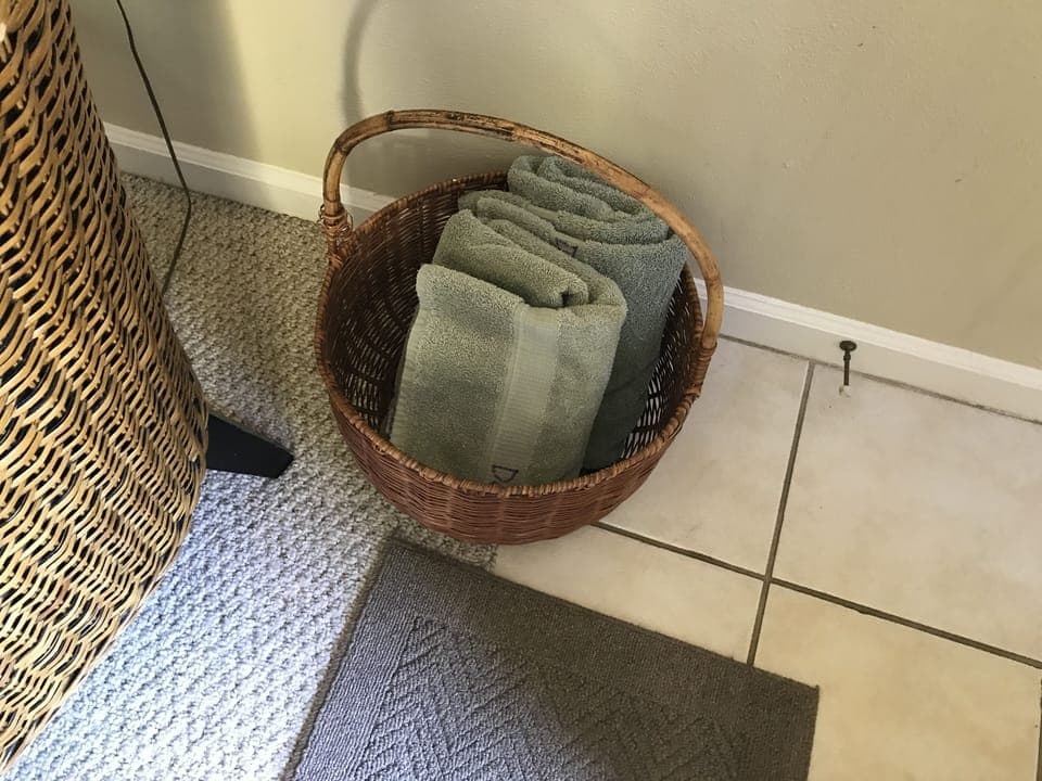 Basket located near the front door contains dog towels for guest use.