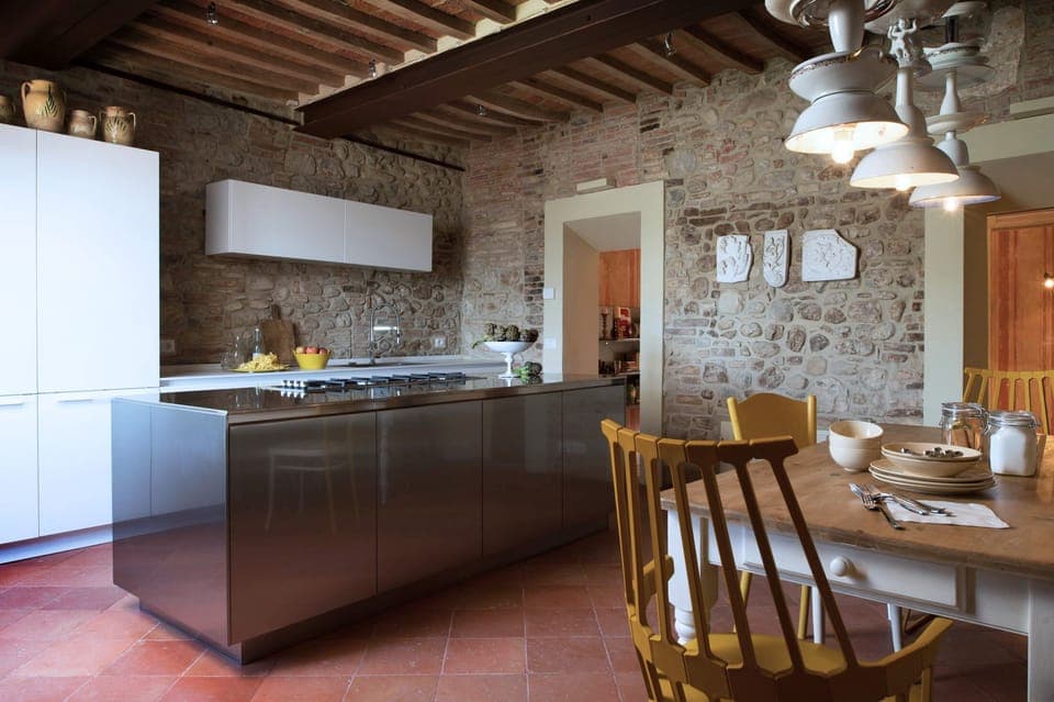 The kitchen with stone walls and modern Poliform cabinets 