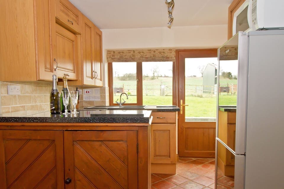 Kitchen with a full oven, 4 ring hob, fridge freezer, and microwave.