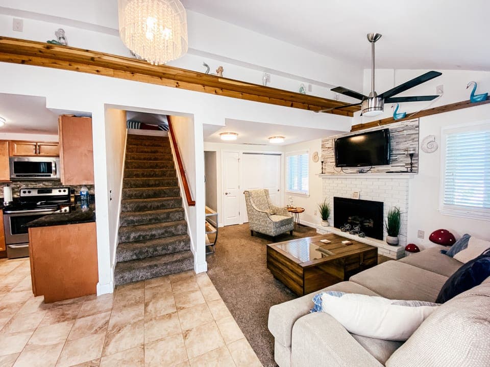 Open plan living area with mounted tv & electric gas fireplace.