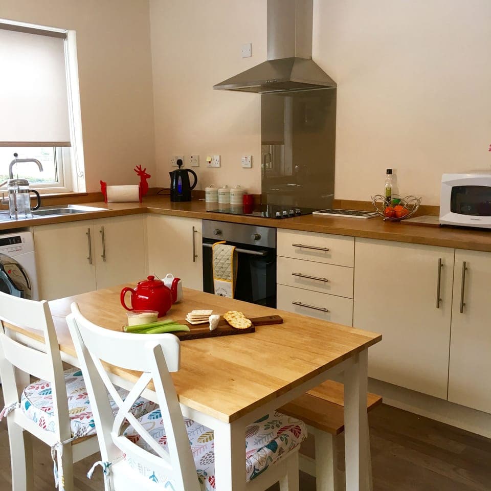Kitchen with table, washer, drier, dishwasher, oven, microwave & slow cooker