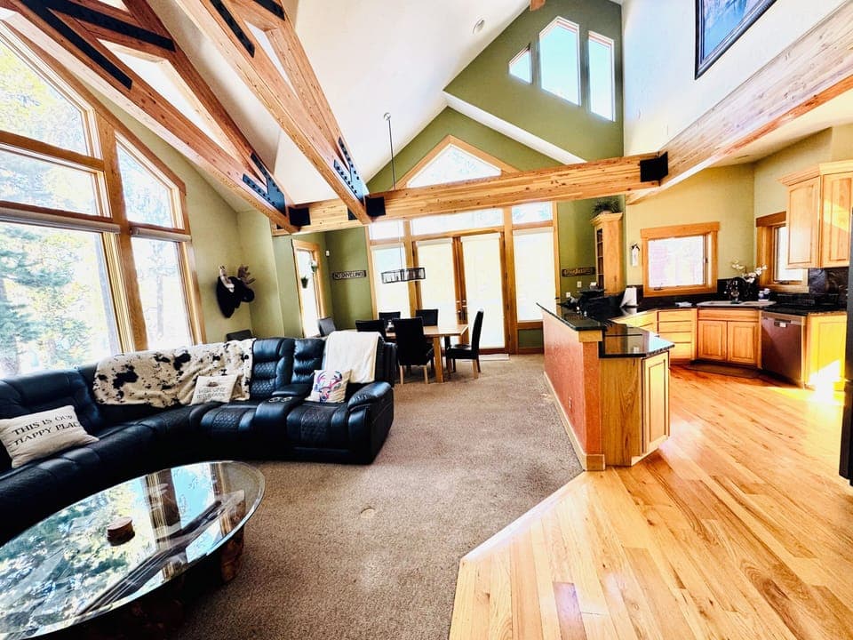 Open floorplan living room with access to kitchen, dining room, bathroom, patio