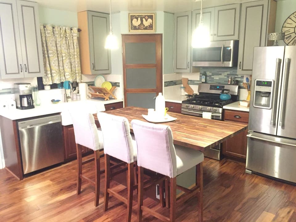 Kitchen with butcher block island, well stocked, with coffeemaker to grind beans