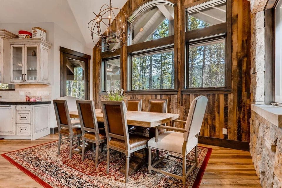 Gather around the beautiful dining table in this spacious and inviting dining room. With floor-to-ceiling windows offering scenic views, it’s the perfect place for memorable meals.