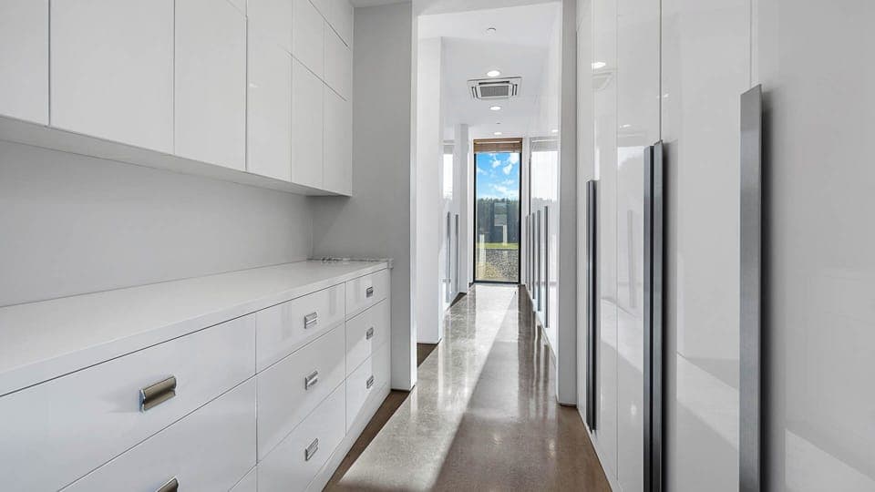 Sleek walk-in closet with ample storage and a bright window view.