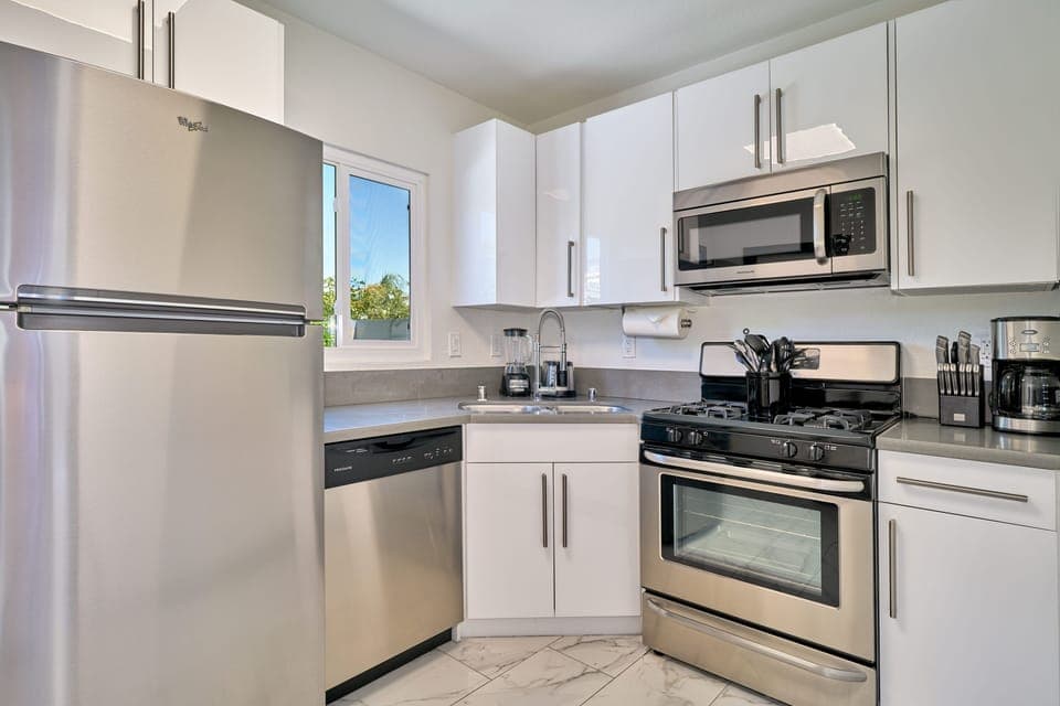 Kitchen with gas range, dishwasher and exit to private backyard. 