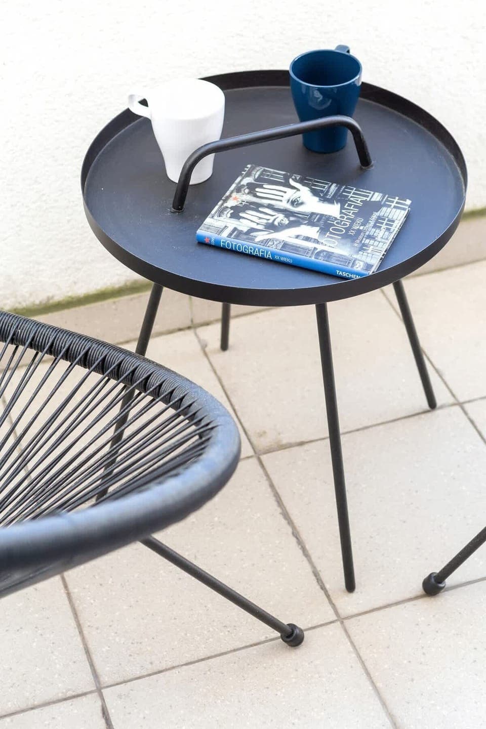 A small coffee table on the balcony with a blue ceramic plate, creating a cozy spot for outdoor relaxation.