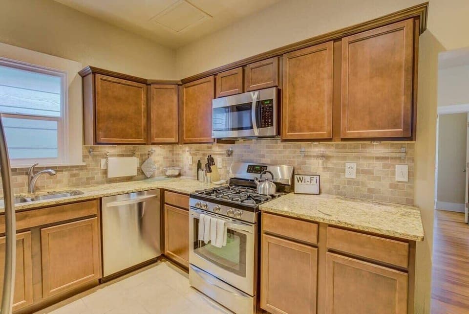 Classic kitchen with wood cabinetry, tiled counters, and a full stove—set out snacks, brew something warm, and cook at your own pace with everything within reach.