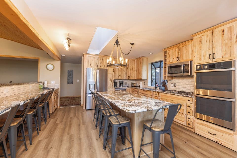 Open kitchen with stainless steel appliances and breakfast table