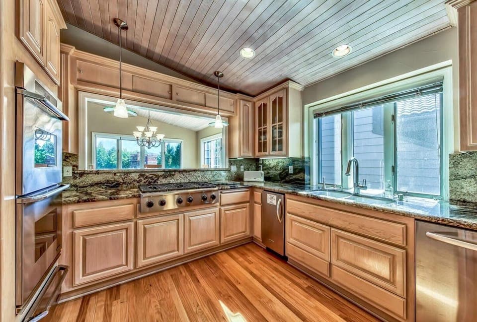 Open kitchen with modern appliances, gas cooktop, electric oven, dishwasher, microwave, coffee maker, and more