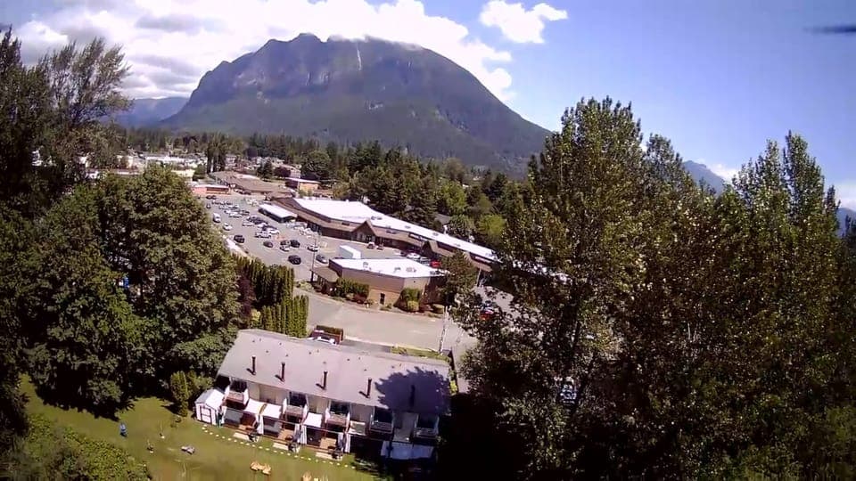 Drone Photo: View of Shopping Center across the street and Mt Si from front of Moon River Suites