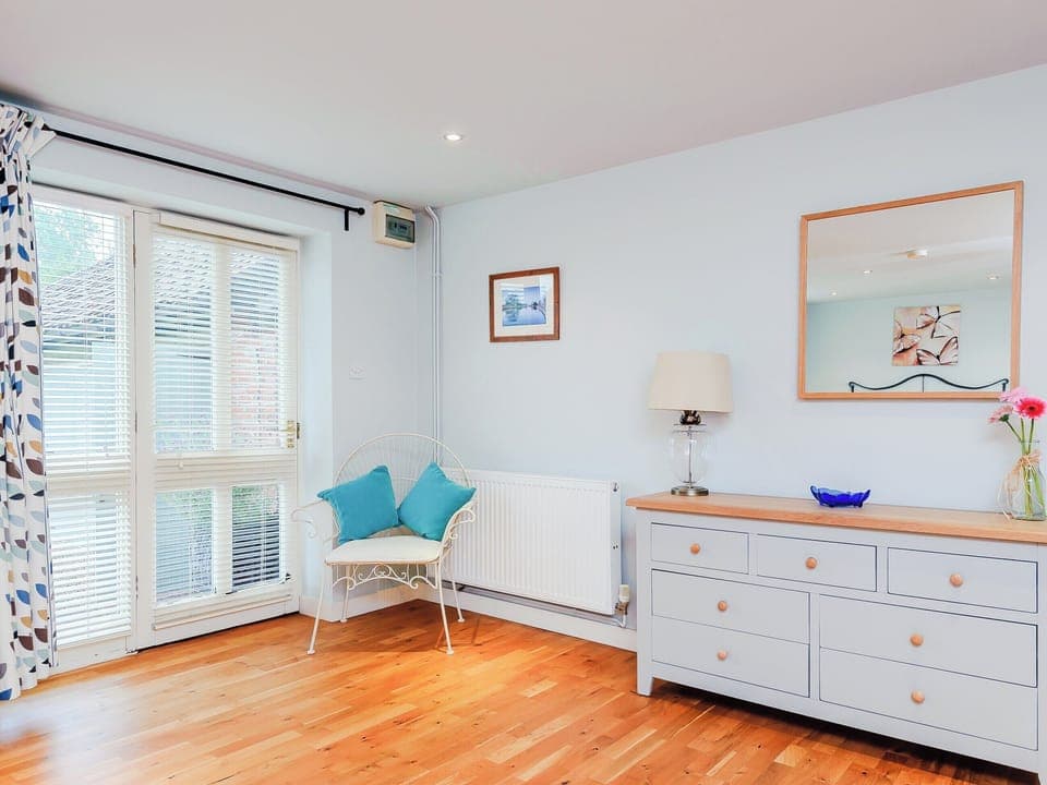 Pretty bedroom with double doors to the garden | Coachman&rsquo;s Cottage - Yaxley Manor Cottages, Yaxley near Eye