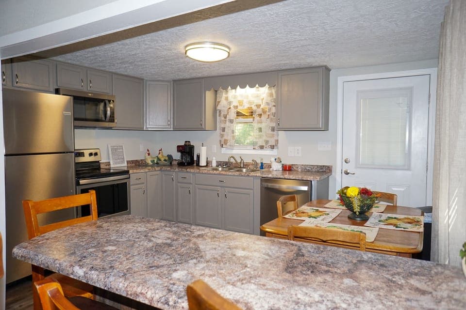 Kitchen - View of kitchen with dining table and bar for additional seating