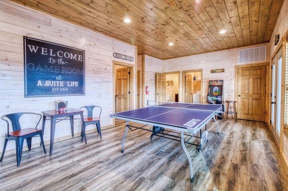 Lower level game room with ping-pong table and hot tub outside on deck.