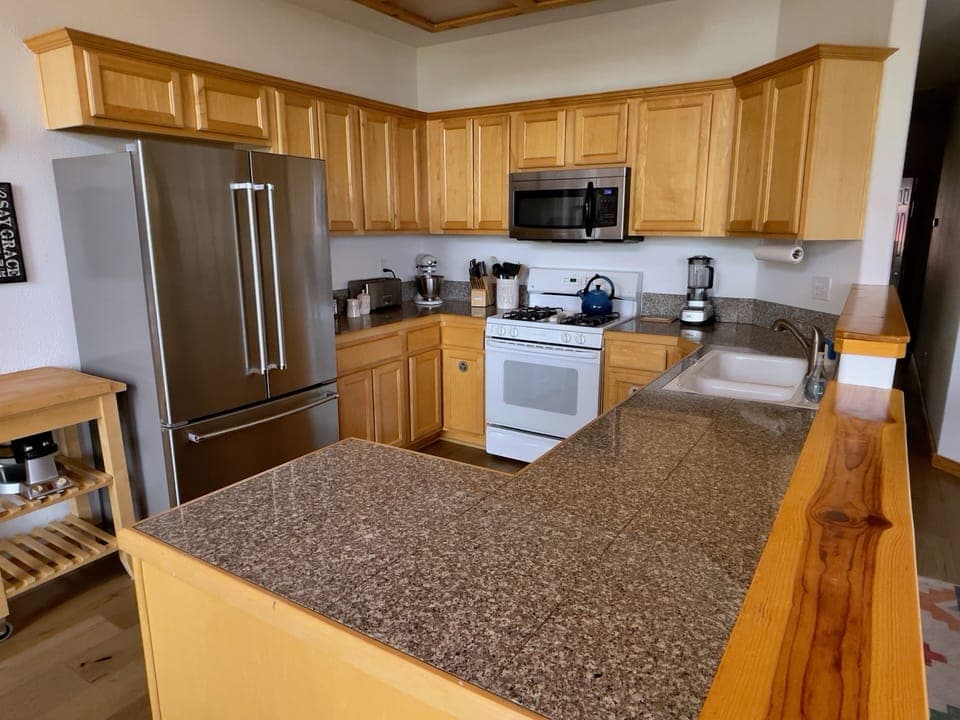 Kitchen w/cooking supplies, provided coffee, milk/cream, and Waffle Maker.