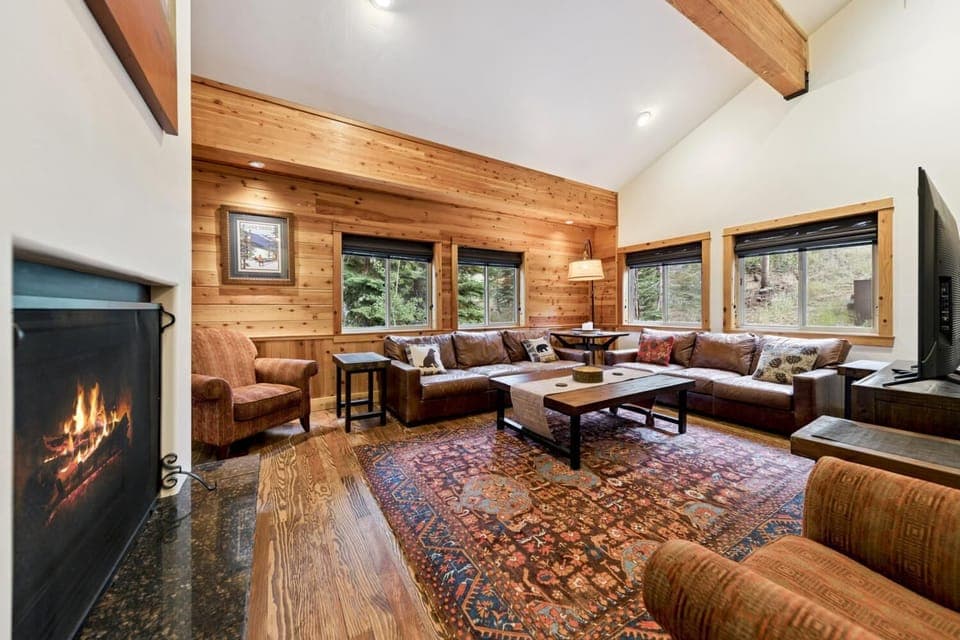 The living room on the main level features a large leather couch, smart TV, and gas fireplace. 