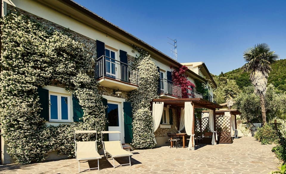 Front of house with glorious jasmine blossom, big shade pergola, table & chairs.