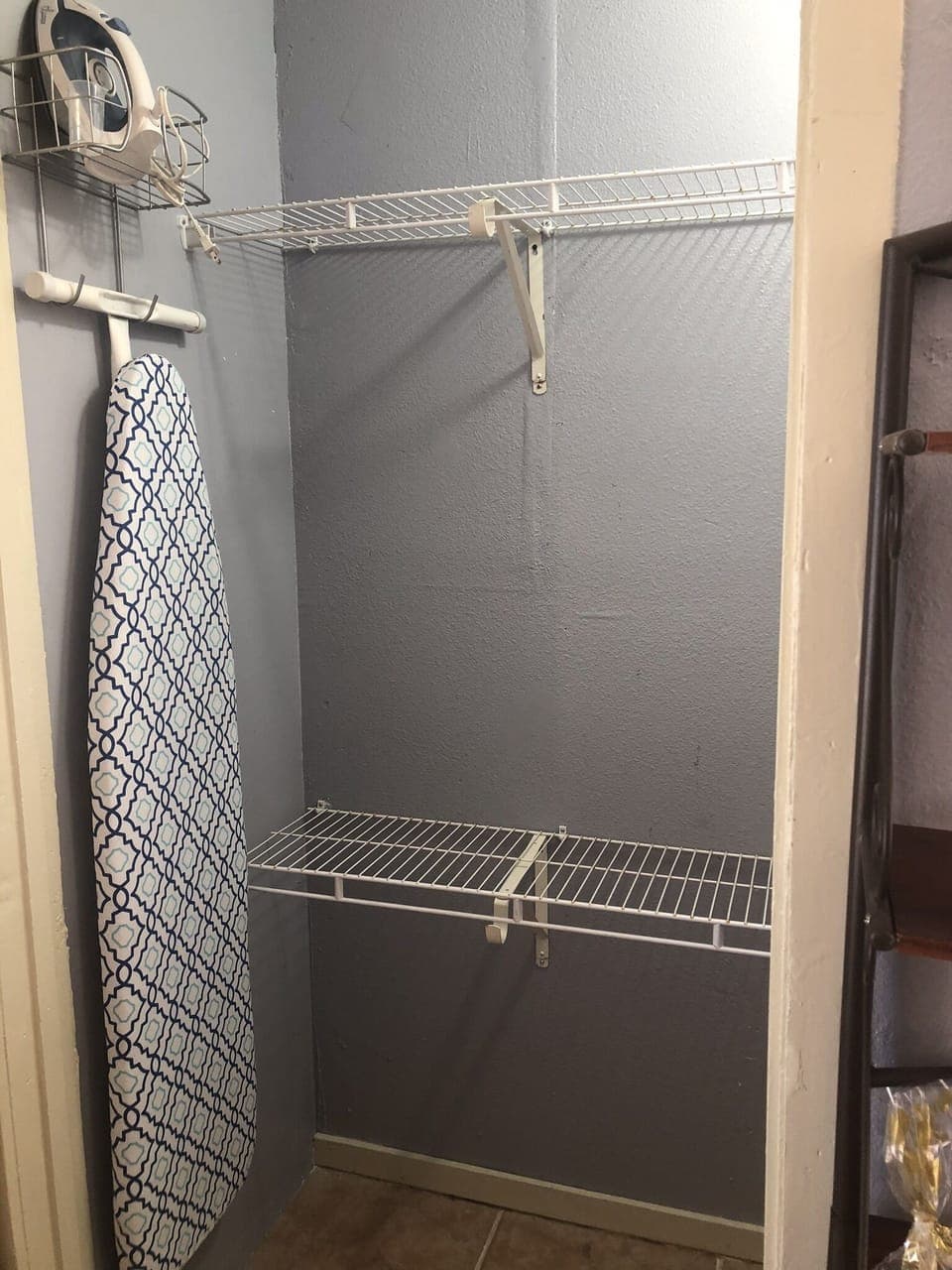 Closet for clothes, ironing board, and iron. 