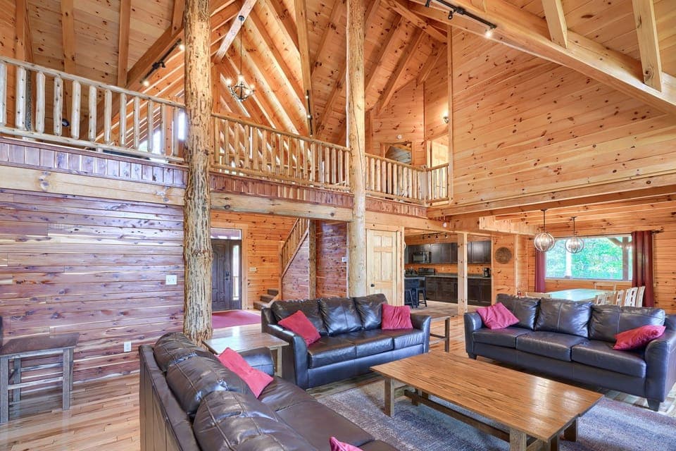 The solid log cabin has tree supports and a high ceiling