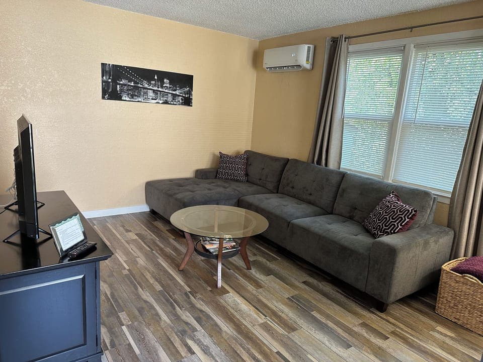 Living room with sectional sofa and mini split 