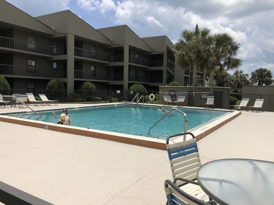 Seawatch's private pool with lounge chairs and tables already setup  