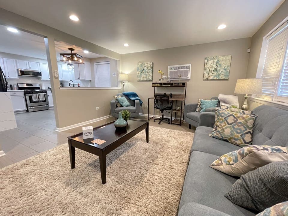 The living room is equipped with Comfy living room seating, & decorative pillows