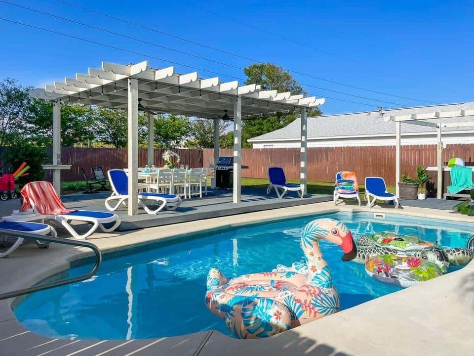 Out back there's a huge pool, a hot tub, a gazebo dining area, and a firepit.