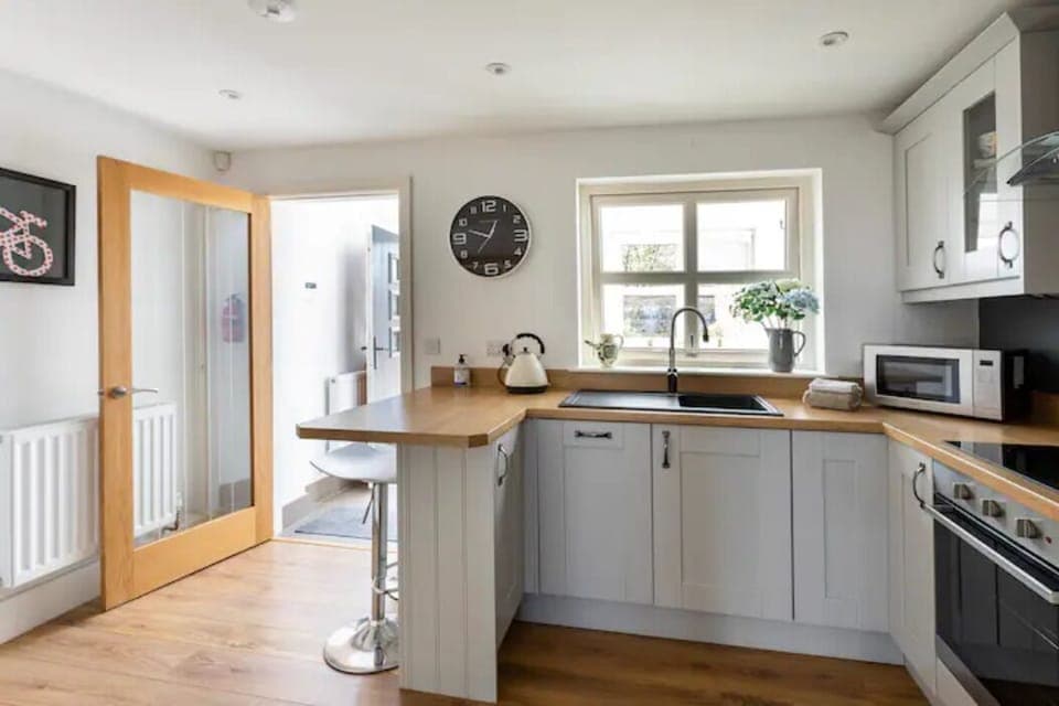 Fully fitted kitchen with breakfast bar and door/window to entrance porch.