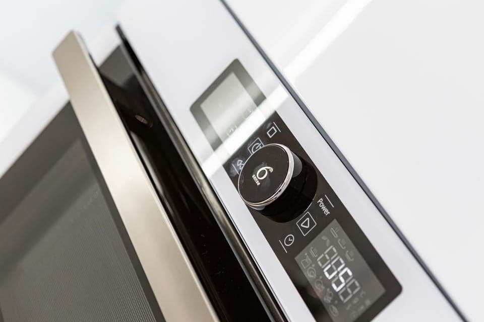 A modern oven and stovetop in a sleek white kitchen setting.