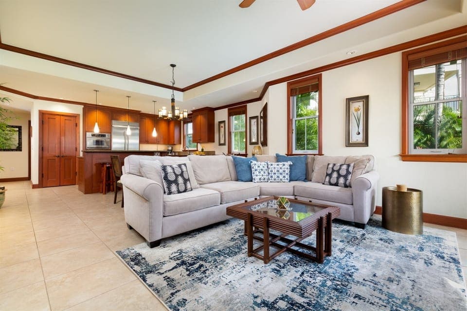 Spacious living room with plush sectional sofa - Open layout connects to modern kitchen and dining area,