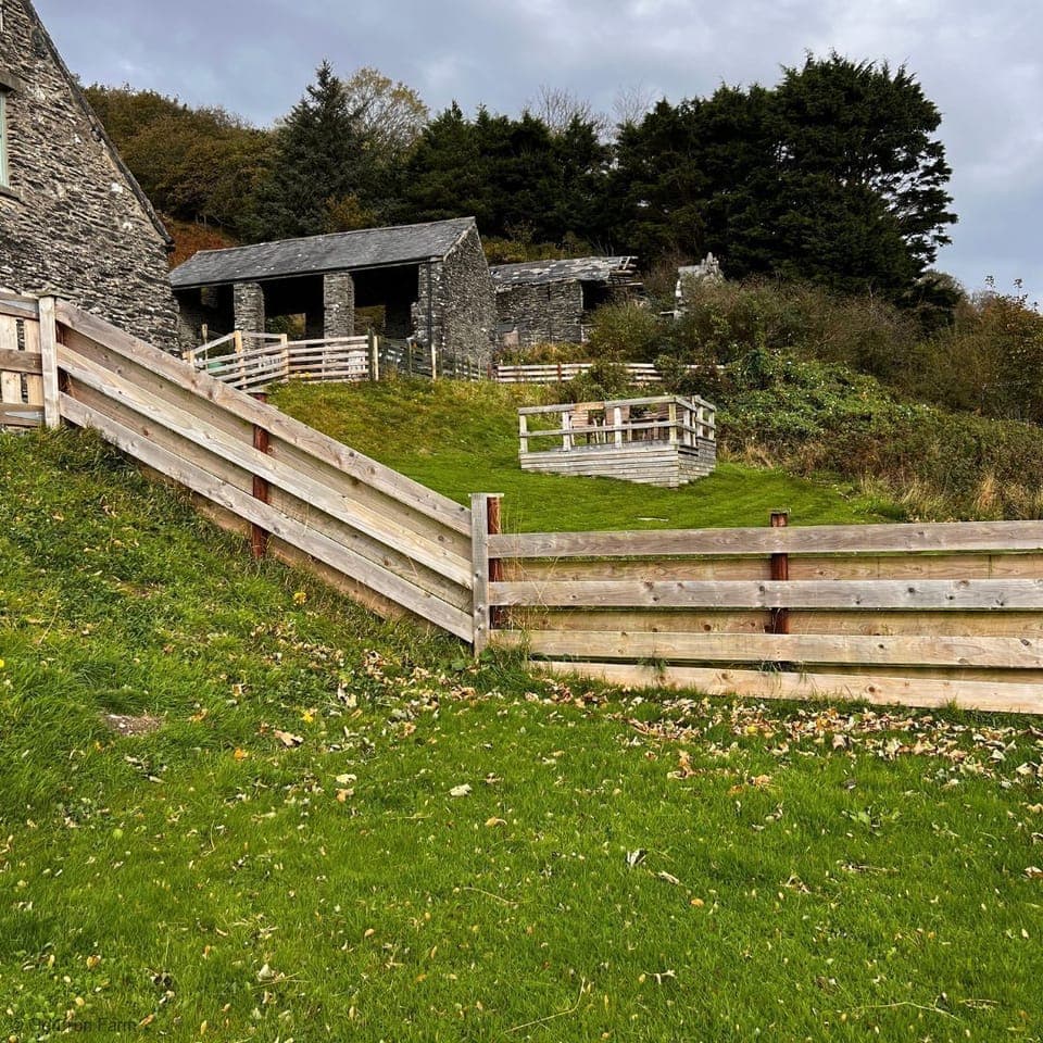 Fence line shared with The Barn . Fences are mix of wooden boards and wire stock fencing.