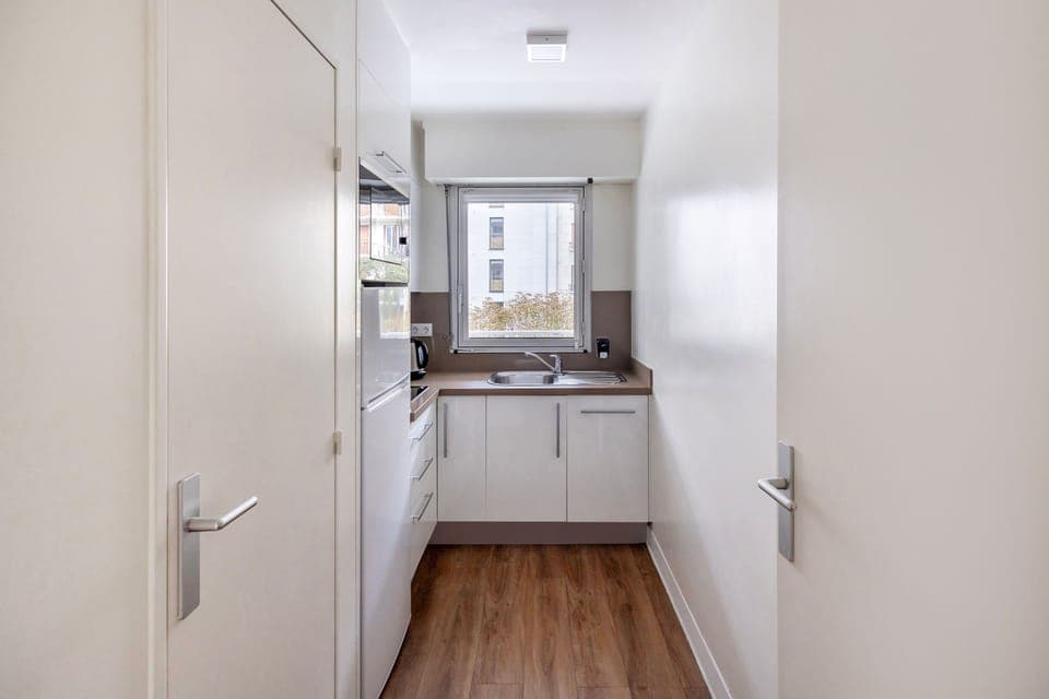 Well equipped kitchen with modern appliances, including a refrigerator, oven, and coffee machine, ideal for preparing your favorite meals.