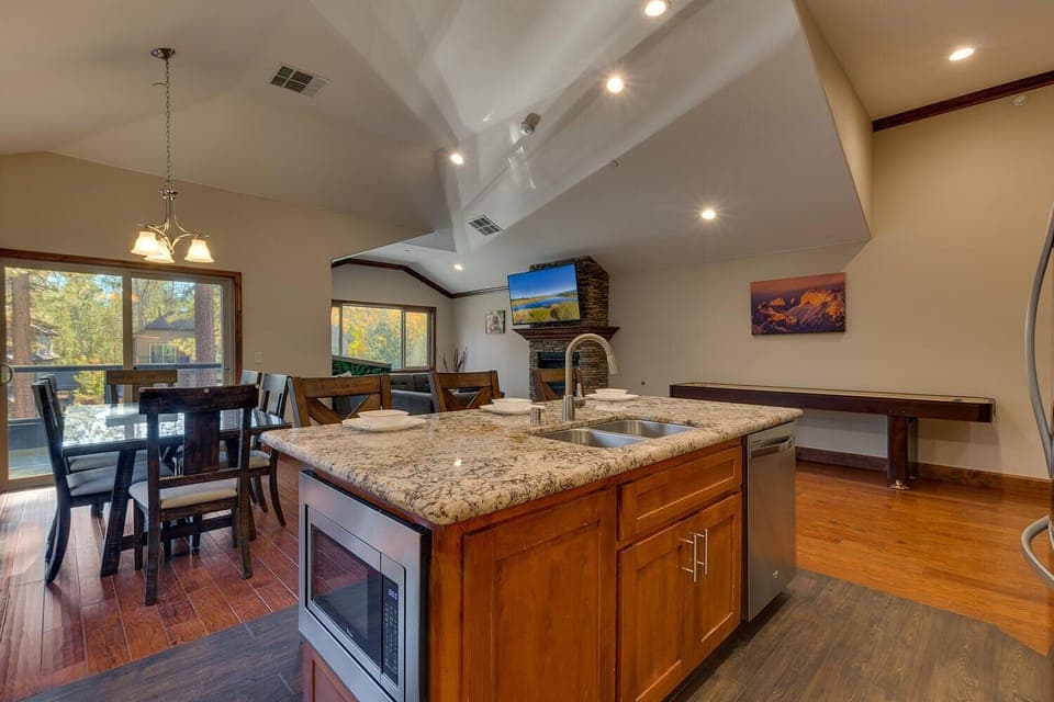 - Granite island with sink and seating  
- Dining area with sliding door to deck  
- Spacious living with fireplace views
