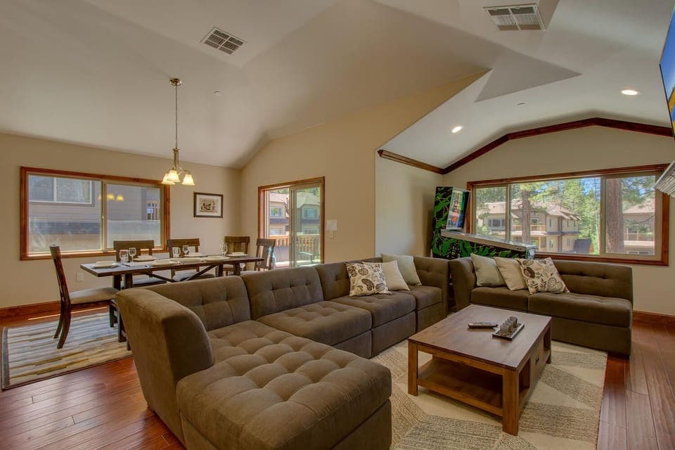 - Large sectional sofa in open living room  
- Dining table with seating for the group  
- Fun arcade game for family entertainment