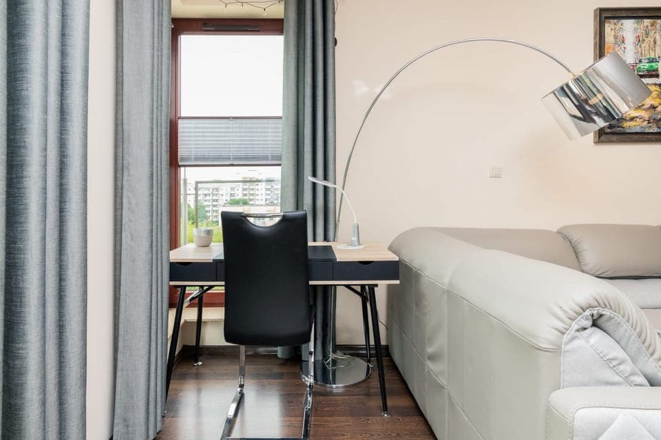 Workspace with a desk by the window and a view of the city.
