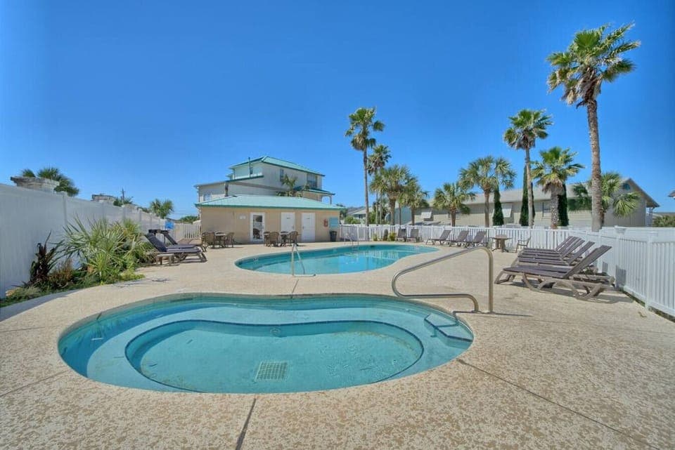 Lounge under swaying palms by the sparkling pool and soothing hot tub.