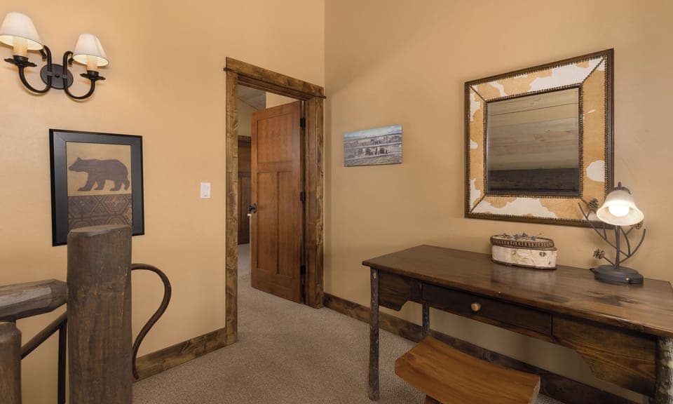 Your rustic workspace awaits with handcrafted wooden furniture, warm lighting, and charming mountain-themed decor to inspire your creative moments.