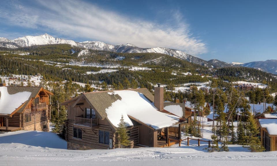 Mountain retreat surrounded by snow-capped peaks and pristine winter landscape in a peaceful alpine setting.