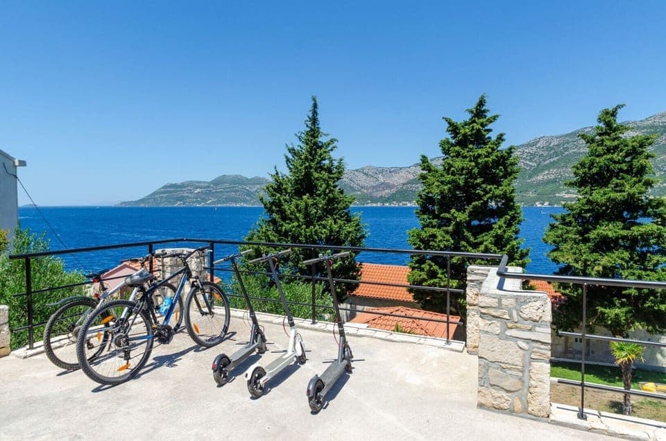 A view of bicycles, romobiles and a table-tennis table next to the luxurious villa Gabriela