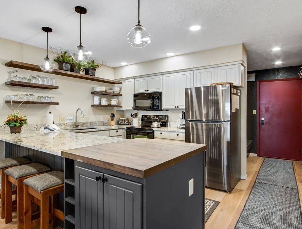 Entertain and Cook with Open Kitchen, Large Butcher Block, and Modern Lighting.