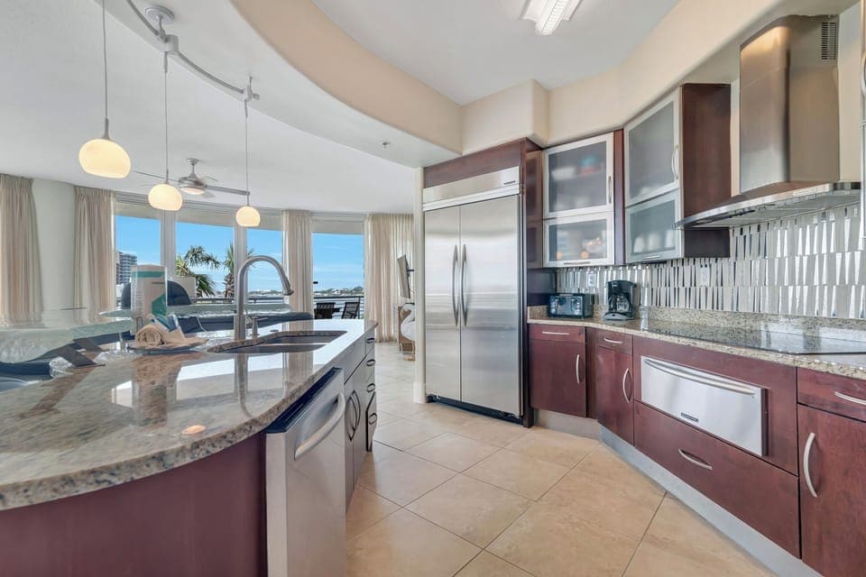 This gourmet kitchen, featuring stainless steel appliances and granite countertops, seamlessly flows into the spacious living area, perfect for entertaining and enjoying breathtaking views.