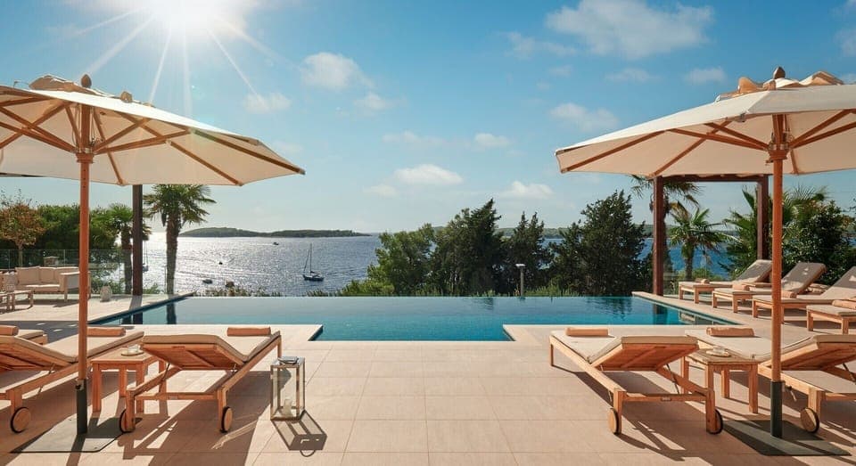 Private terrace of Croatia luxury villa for rent with heated pool surrounded by deckchairs and sundeck
