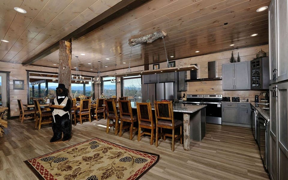 Open kitchen flows into a rustic dining area, accented by a charming bear butler.