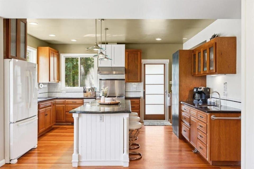 Main House - Spacious kitchen with modern appliances and warm wood accents