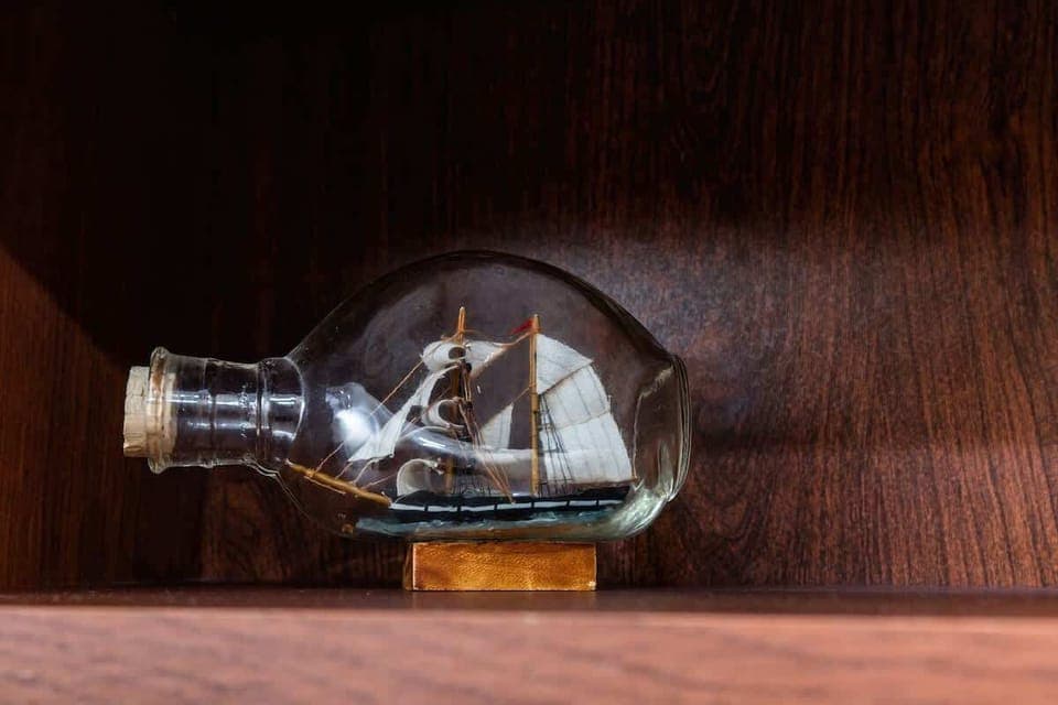 Decorative model ship in a glass case, adding a unique touch to the living room's decor.