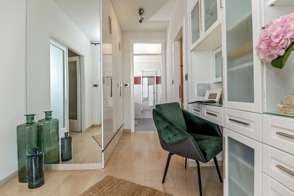 Seating area with dresser in Brač luxury villa for vacation and rent with private pool by the sea decorated with vase and flowers.