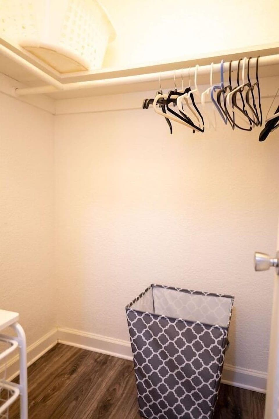 Walk in closet includes hangers, laundry basket and plenty of storage