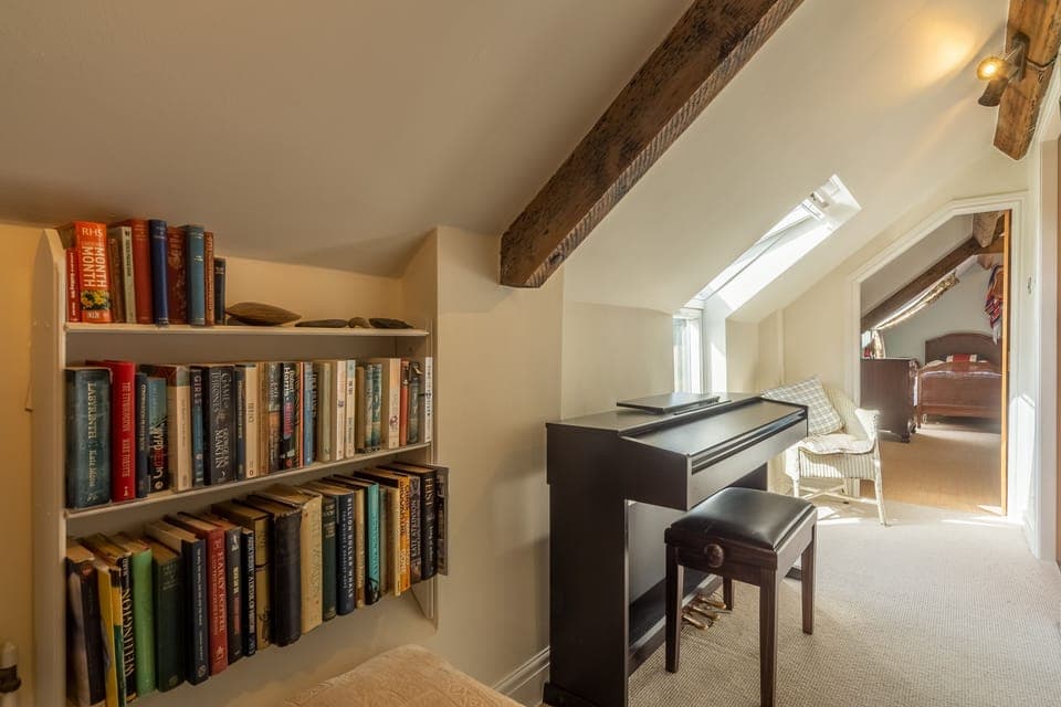 First floor: Hallway with books and piano