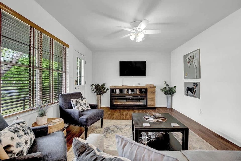 In this snug living room adorned with whimsical art, a flatscreen TV beckons from across the room, surrounded by plush, inviting furnishings that promise a haven of comfort and entertainment.